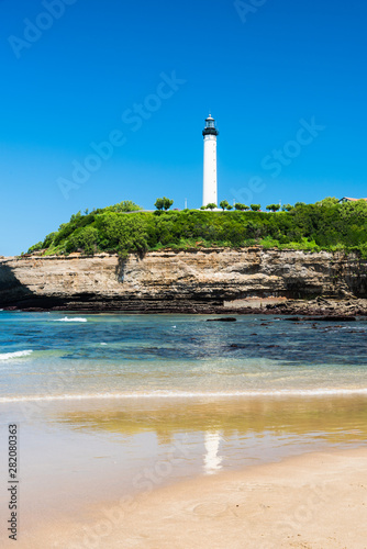 The lighthouse of Biarritz with its reflection in the water on the beach. Basque country of France