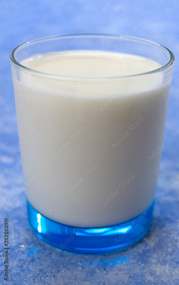 Glass of milk on a light blue background. Glass of milk on a light blue background.
