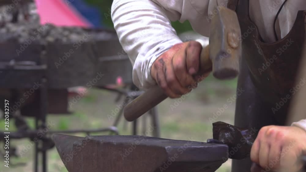 Blacksmith at work in outdoor smithy during Slavic and old culture days in Sobotka, Poland. Slow motion. Blacksmith at work in outdoor smithy during Slavic and old culture days in Sobotka, Poland. Slow motion.