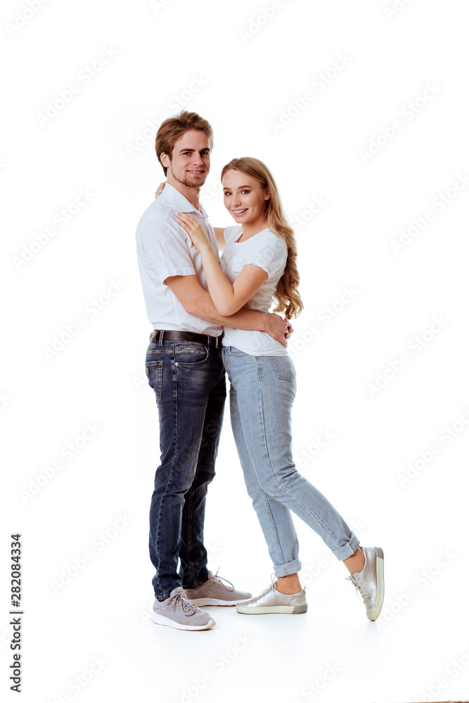 Beautiful young couple in casual clothing flirting, white background Beautiful young couple in casual clothing flirting, white background