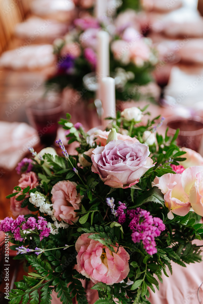 Vintage festive table setting with pink roses, candles and cutlery on an old wooden board