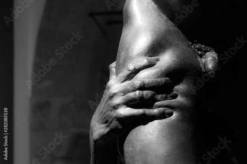 Foto Stock Dettaglio di una statua in bianco e nero che ritrae una mano che  stringe la gamba di un uomo nudo | Adobe Stock