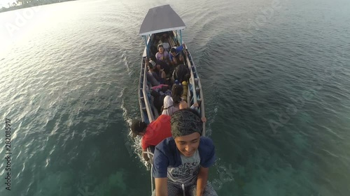 Men and women in sitting in the traditional boat during vacation to the island