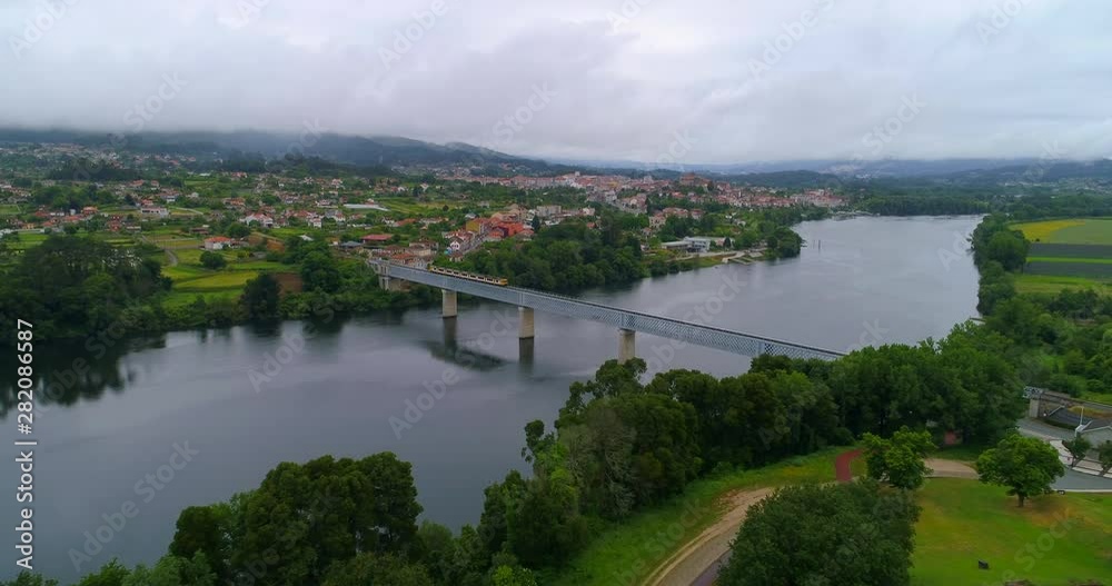 Aerial Forward: Train Passing Short Bridge Over the Water in Valenca Portugal Aerial Forward: Train Passing Short Bridge Over the Water in Valenca Portugal
