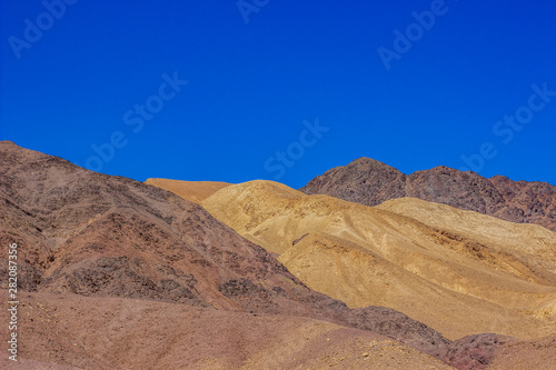 colorful desert sand stone hills dry scenic landscape photography of wilderness and dangerous natural environment  blue sky background 