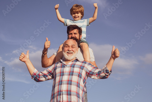 Father son and grandfather playing - family time together. Boy with father and grandfather. Male multi generation portrait. Three men generation. © Volodymyr