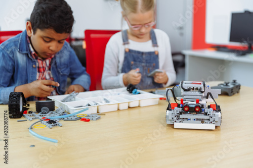 Mixed Racial group of School kids sitting at class with diy robot, stem education concept.