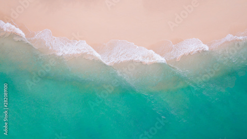 Beach top view. Aerial view sand beach wave foam from turquoise water on the tropical island