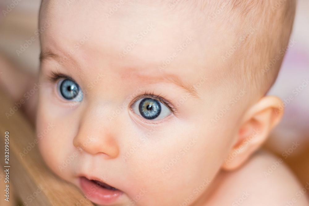 Amazed baby looks in surprise, big open eyes, close up Amazed baby looks in surprise, big open eyes, close up