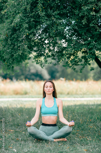 Brunette fitness girl doing yoga outdoor.