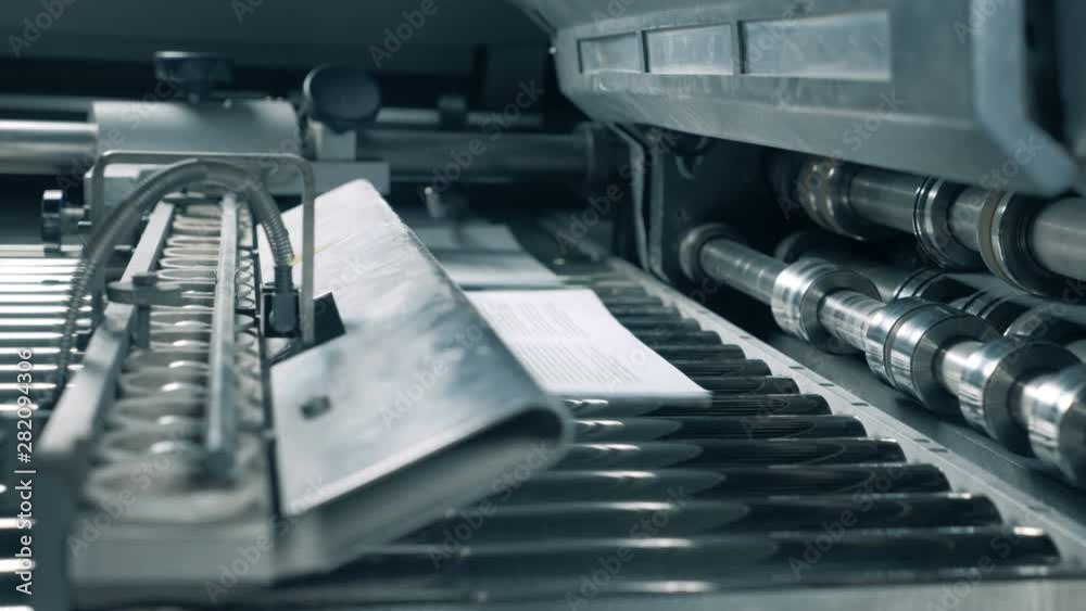 Working conveyor moves printed paper in a typography room. Working conveyor moves printed paper in a typography room.