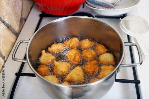 Fried balls are fried in oil on the stove. Preparing a homemade dessert on the traditional way photo