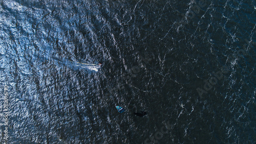Aerial view of many people who make kitesurfing activity  on beach 