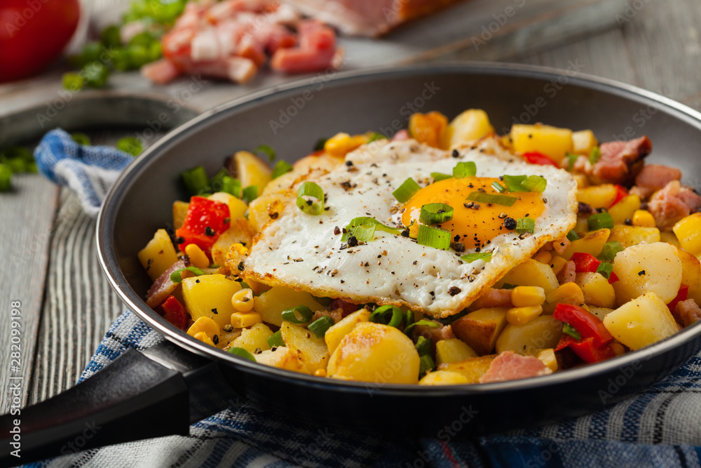 Traditional American hash with fried eggs. Front view. Traditional American hash with fried eggs. Front view.