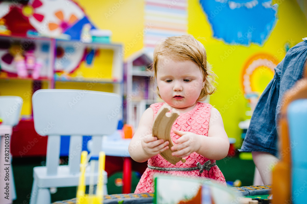 Happy children, girls are playing toys in the children's playroom on their birthday. Happy children, girls are playing toys in the children's playroom on their birthday.
