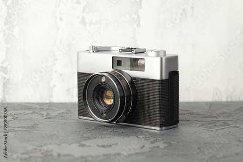 The vintage rangefinder automatic film camera on grey cement background.