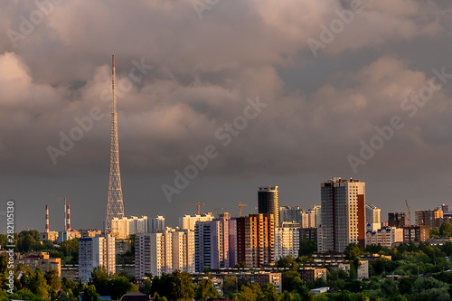 In the foreground is one of the Central districts of Perm in the evening. High-rise buildings and an old TV tower are illuminated by the rays of the dim setting sun.