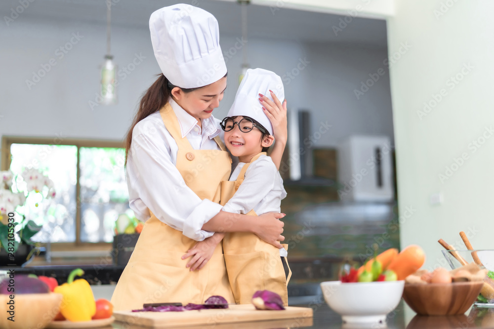 Happy family asian mom hugging little son cooking salad vegetable prepare healthy food in the kitchen room for dinner at home lifestyle. Happy family asian mom hugging little son cooking salad vegetable prepare healthy food in the kitchen room for dinner at home lifestyle.