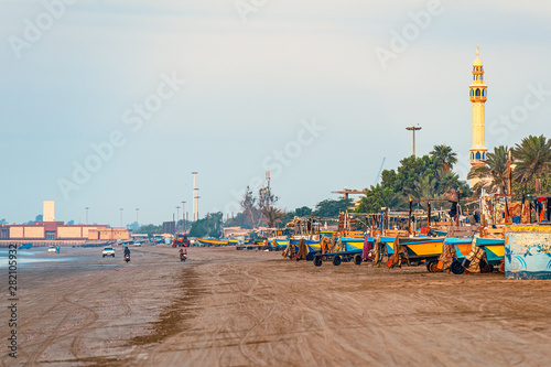 05/11/2019 Bandar Abbas, Hormozgan Province, Iran, many colorful fishing boats on the Persian Gulf coast stand at dawn and wait for the beginning of the working day. photo