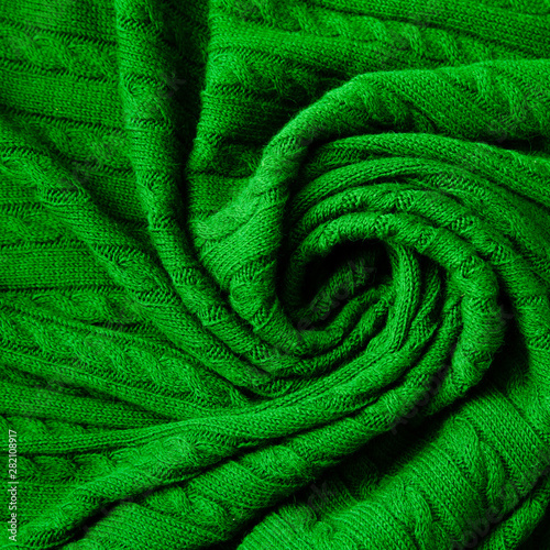 Texture of knitted green fabric. Crocheted abstract background.