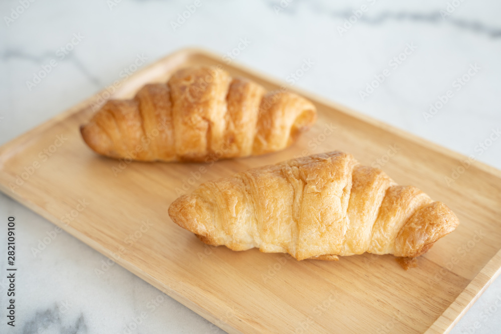 A Couple of Croissants on the wooden plate.