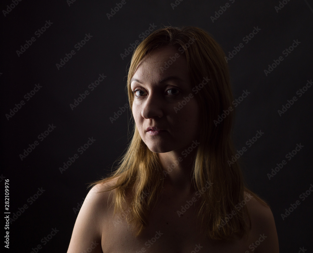 Fototapeta premium portrait of young woman, no make up, low key, brown dark hair, natural looking making expressions 