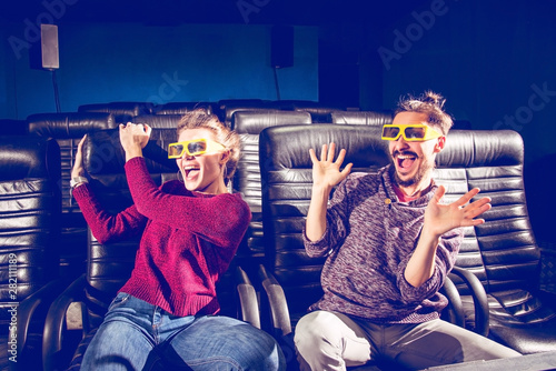 guy and girl 3d glasses are very worried while watching a movie in a cinema