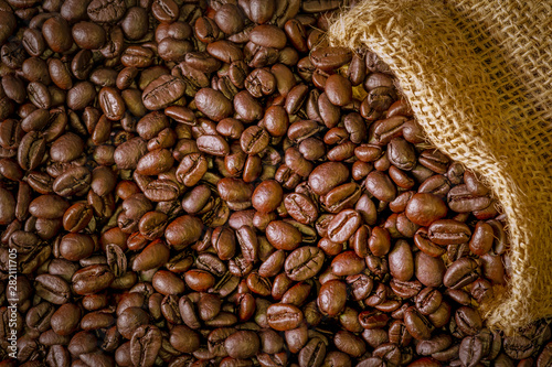 Coffee beans in a sack on dark brown background. © otello-stpdc