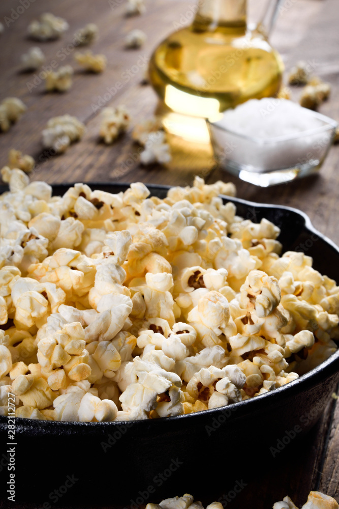 Prepared popcorn in frying pan, corn seeds in bowl and corncobs on kitchen table.Air salty popcorn. Salt popcorn on the wooden background . Chees .Popcorn texture Prepared popcorn in frying pan, corn seeds in bowl and corncobs on kitchen table.Air salty popcorn. Salt popcorn on the wooden background . Chees .Popcorn texture