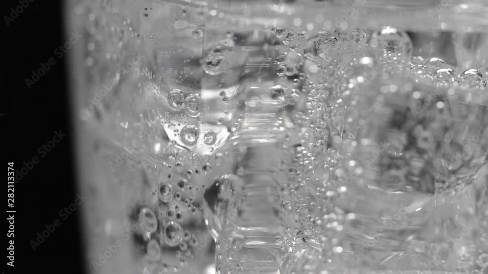 Close-up ice and soda water with bubbles background in slow motion Close-up ice and soda water with bubbles background in slow motion