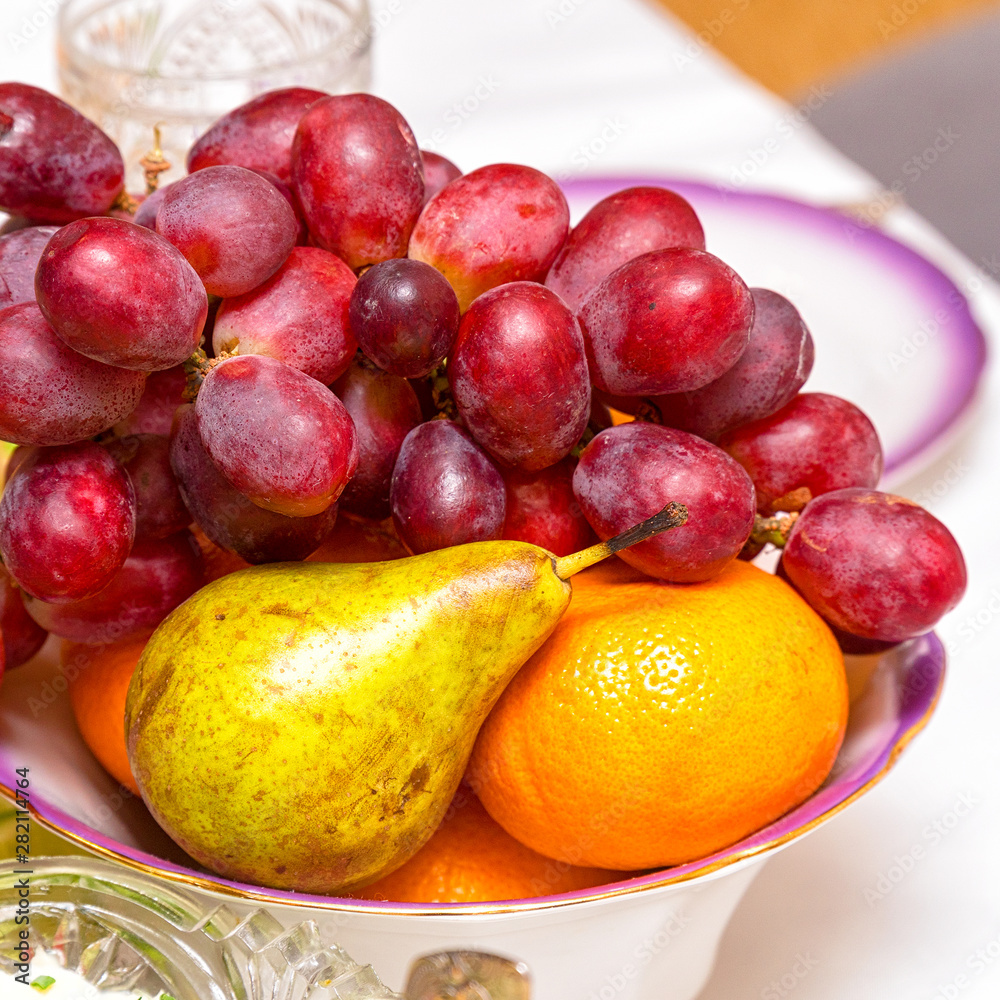 A bunch of grapes, pear and orange on the plate A bunch of grapes, pear and orange on the plate