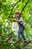 Child concept. Rope park - climbing center. Hike and kids concept. Go Ape Adventure. Happy Little child climbing a tree.