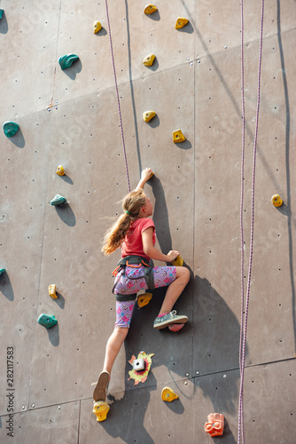 The girl on the tower of climbers conquers the peaks in an extreme park.