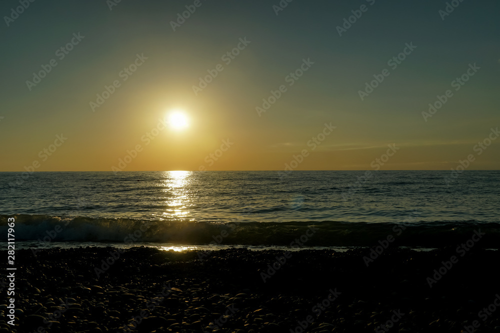 Fototapeta premium Beautiful sunset on the Black Sea in Batumi, Georgia. Dazzling orange sunset on the black sea, the sun goes over the sea