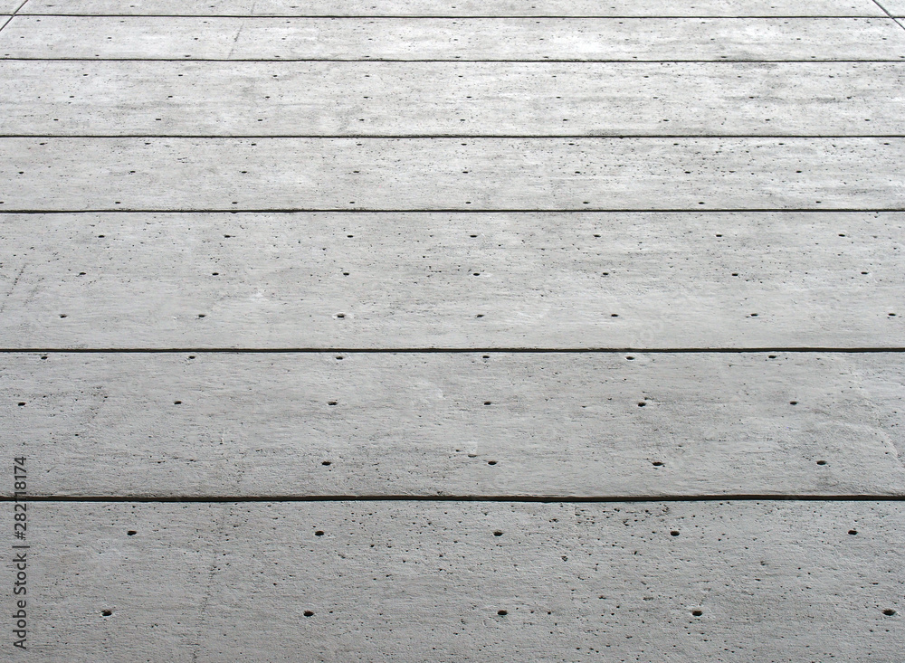 a perspective view of a large grey textured concrete wall with black horizontal lines and a pattern of repeating dots a perspective view of a large grey textured concrete wall with black horizontal lines and a pattern of repeating dots