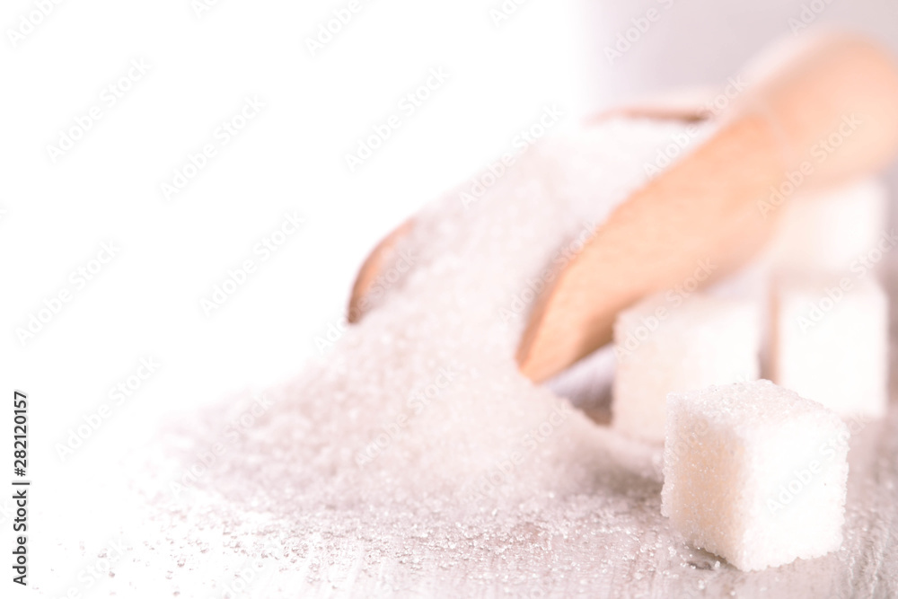 White cane sugar on a light wooden background White cane sugar on a light wooden background