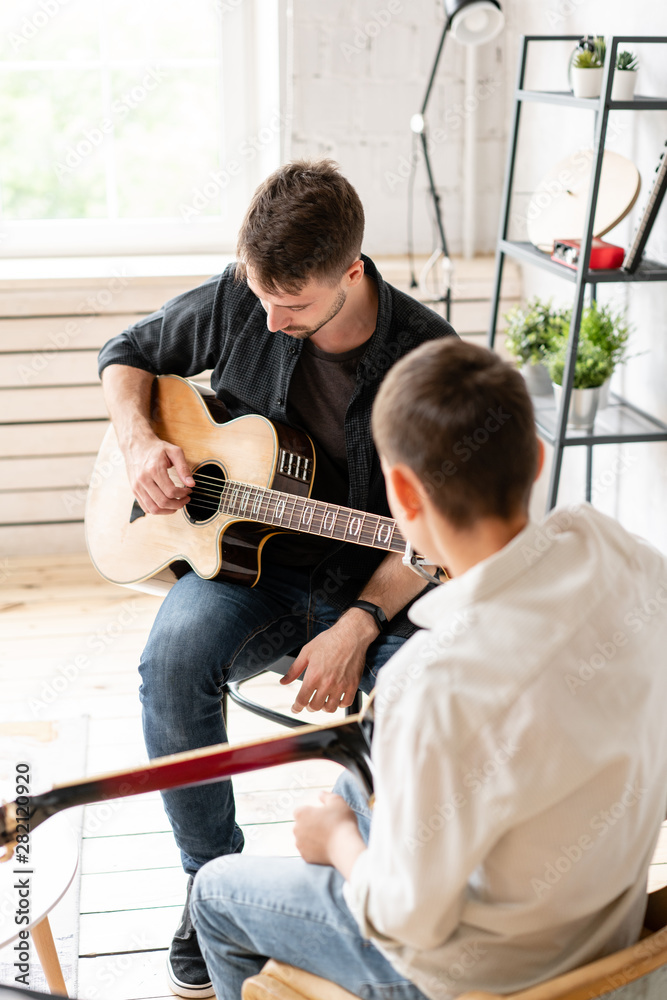 custom made wallpaper toronto digitalThe young teacher shows the correct position of the hands in the guitar on his example