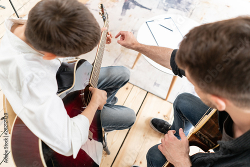 Wallpaper Mural Adult man explains his son, who learn to play guitar, how to play studied chord correctly. Education with family Torontodigital.ca