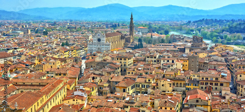 Aerial view. Top of buildings in the old city with Basilica di Santa Croce in a distance and green hills in the background. Panoramic skyline. Italy, Florence