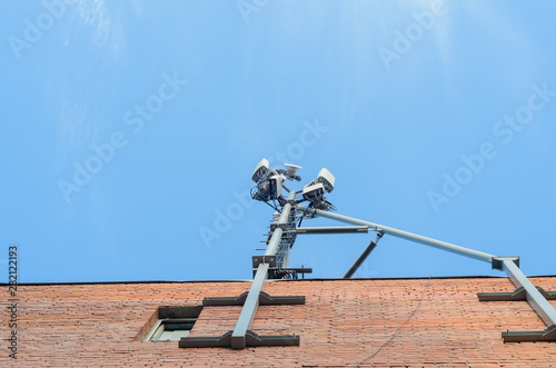 Wallpaper Mural Cellular antenna on the roof of a brick house on blue sky background. Torontodigital.ca