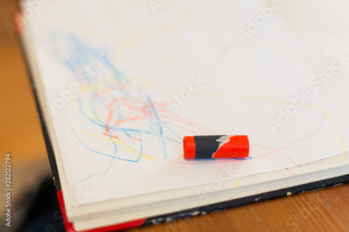 a single red crayon on a drawing of a child