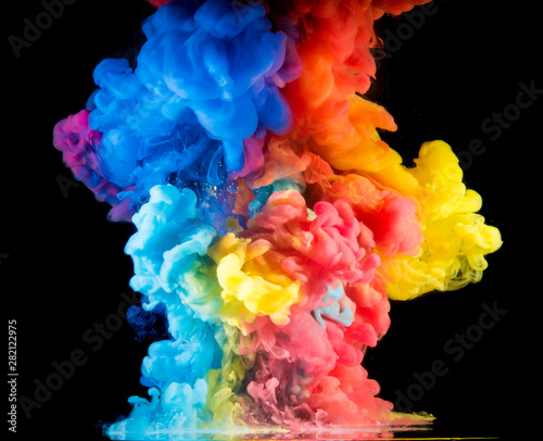 Colorful paint drops from above mixing in water. Ink swirling underwater