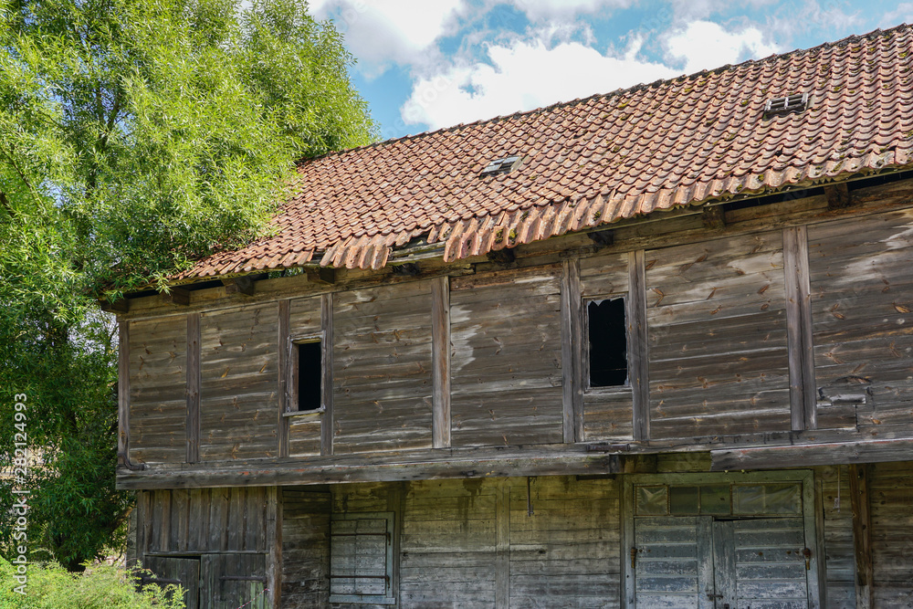 old abandoned wooden house with a crumbling clay roof old abandoned wooden house with a crumbling clay roof