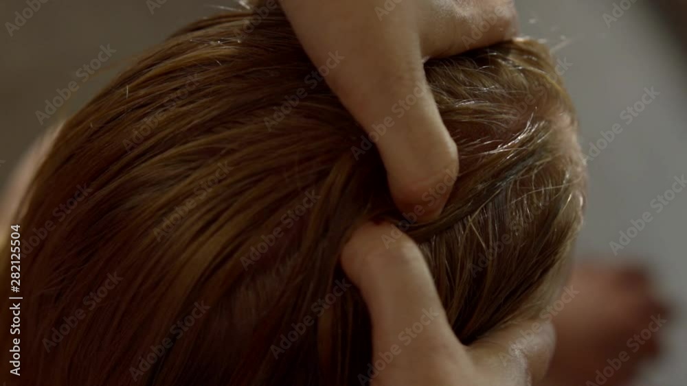 masseur is touching and pressing acupuncture points on head of client, close-up