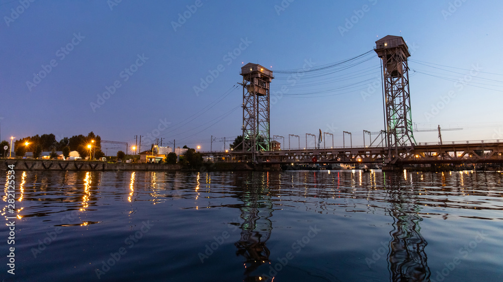 large iron bridge with two tall towers at dusk