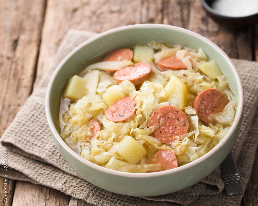 Fresh homemade cabbage, potato and sausage stew in bowl (Selective Focus, Focus one third into the dish) Fresh homemade cabbage, potato and sausage stew in bowl (Selective Focus, Focus one third into the dish)