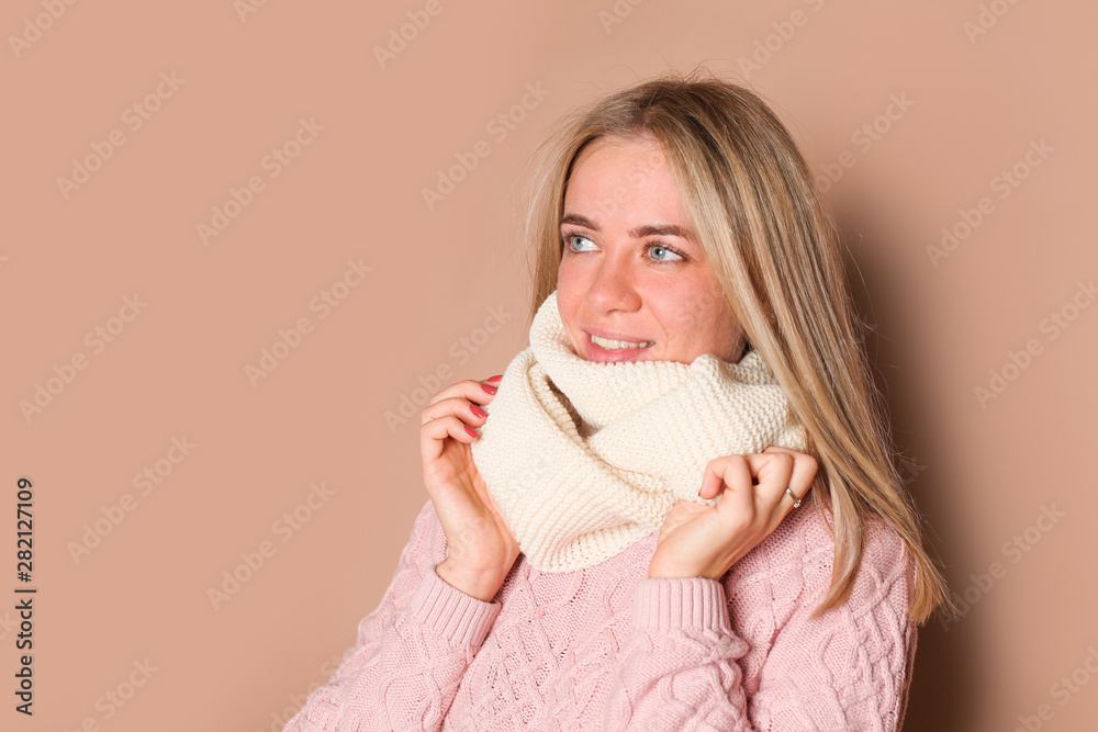 Young woman in winter hat, pink sweater, beige background Young woman in winter hat, pink sweater, beige background
