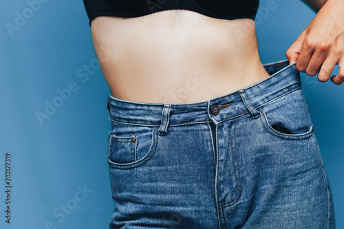 skinny woman body with Loose pants jeans, Light weight body with loose clothes, slender and Healthy body low fat concept © Anastassiya 