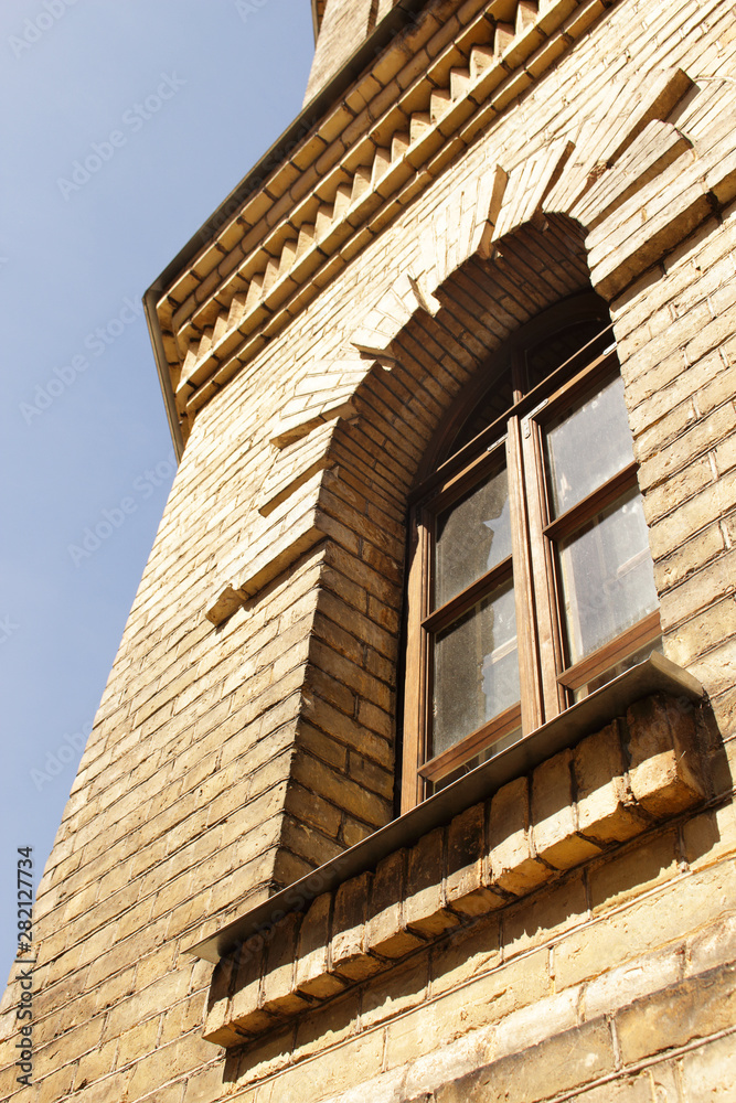 Old water tower building yellow brick wall and architecture window European architecture on blue sky background Old water tower building yellow brick wall and architecture window European architecture on blue sky background