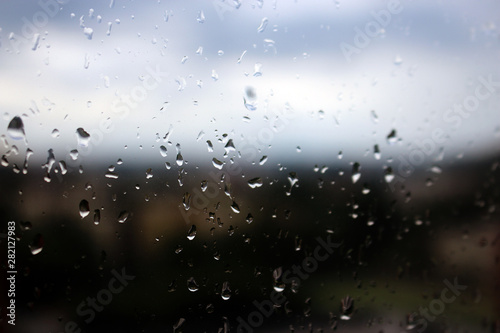 Big rain drops on clear window glass
